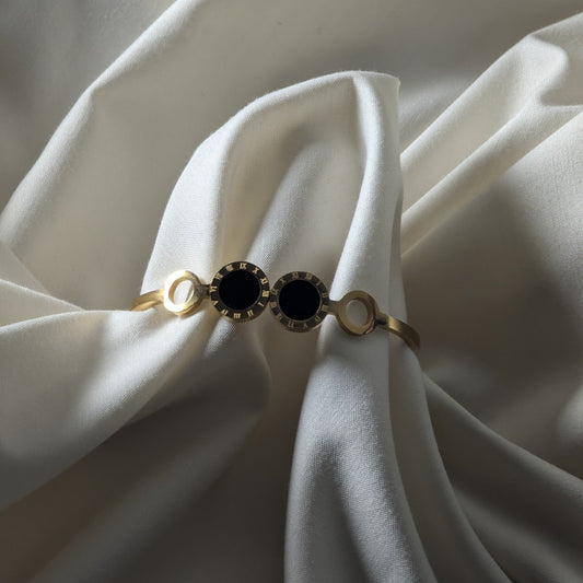 Bracelet with black gemstone on a white fabric background