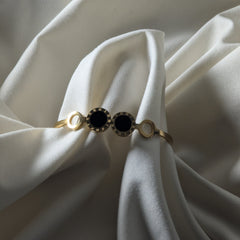 Bracelet with black gemstone on a white fabric background