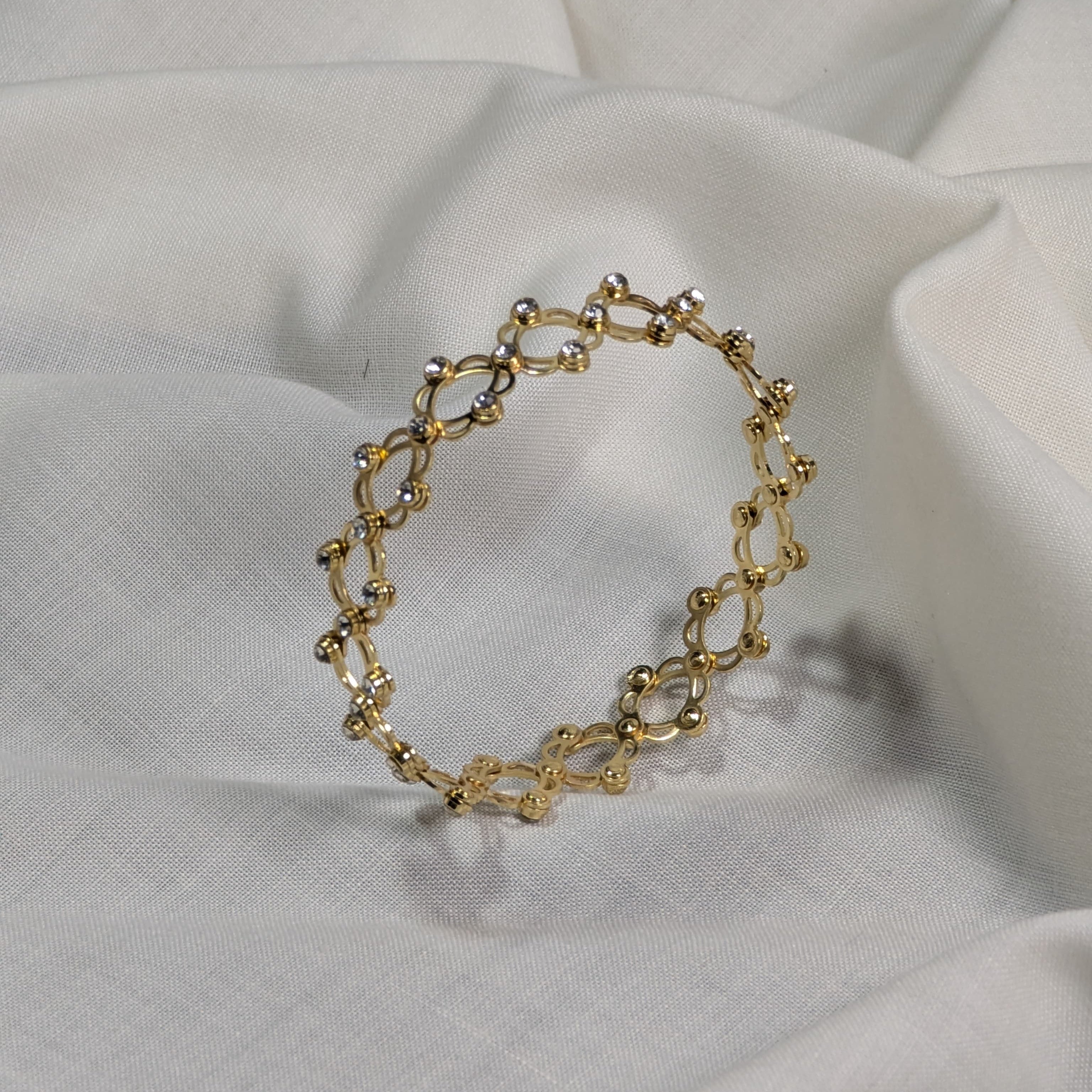 Gold bracelet on a white fabric background