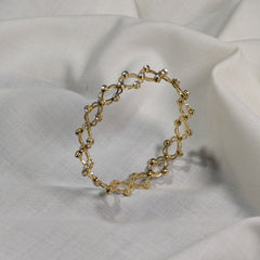 Gold bracelet on a white fabric background