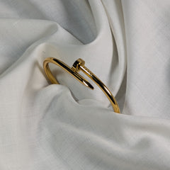 Gold bracelet on a white fabric background