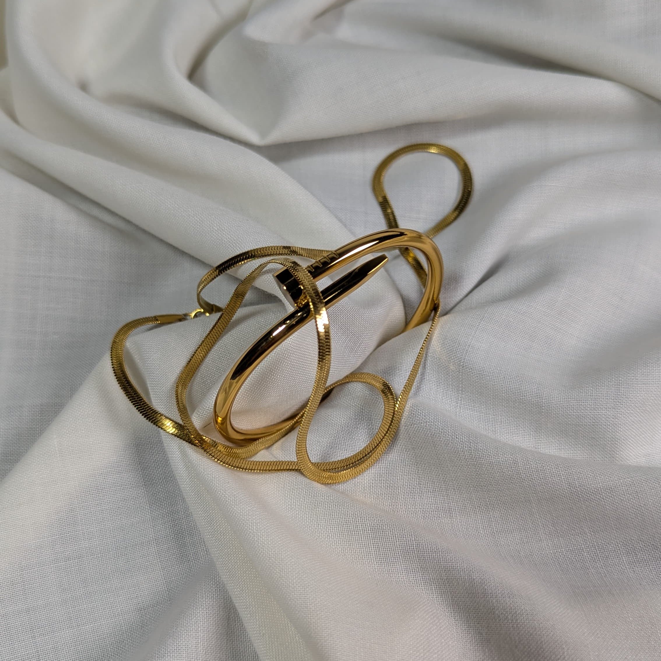 Gold ring with a unique design on a white fabric background