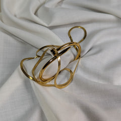 Gold ring with a unique design on a white fabric background
